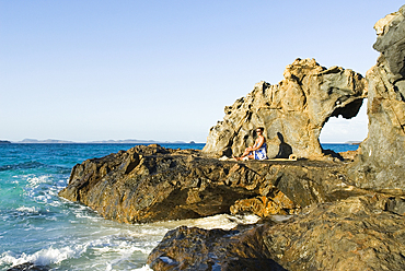 Young woman relaxing in the sun in rocks by the sea, Tsarabanjina island,Mitsio archipelago,Republic of Madagascar,Indian Ocean