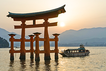 The iconic torii and a tourist cruise boatat the Itsukushima Shrine, on Miyajima island, hiroshima Prefecture, Japan