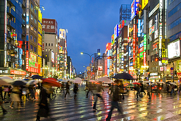 Shinjuku district illuminated in the rain at dusk , Tokyo, Japan