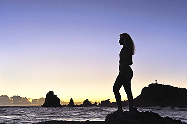 Girl standing on rocks admiring sunrise at Pointe des Chateaux, Grande-Terre, Guadeloupe, overseas region of France,Leewards Islands, Lesser Antilles, Caribbean