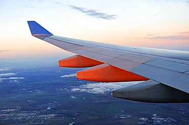 aile d'avion de ligne en vol vu a travers un hublot au coucher du soleil//in-flight airliner wing seen through the window at sunset