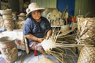 Woman making basketworks with Common screwpine's leaves, Reunion island, Overseas departement of France, Indian Ocean