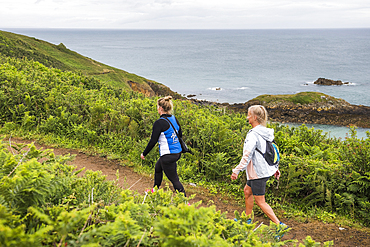 Two women hiking on the south coast trail on Herm Island, Bailiwick of Guernsey, United Kingdom