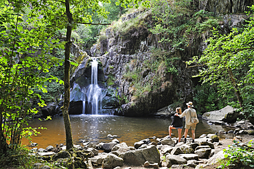 Father and his daughter admiring the waterfall of Gour Saillant fed by the Auzelle, a sub-tributary of the Sioule River, Saint-Priest-des-Champs, Puy-de-Dome department, Auvergne-Rhone-Alpes region, France, Europe