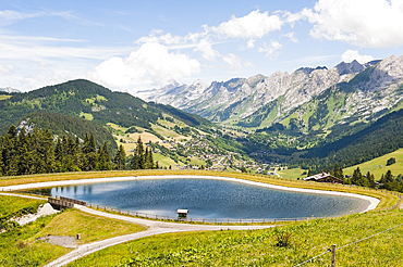 Reservoir,high mountain pasture of Corbassieres in Beauregard range with Aravis range in the background, near La Clusaz, Haute-Savoie department, Rhone-Alpes region, France, Europe