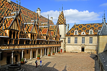 Inner courtyard surrounded by polychrome tiles of the roof at Hotel-Dieu of Beaune,Cote-d Or department,Burgundy region,France,Europe