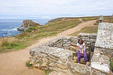 Young girl washing her hands at Saint-They fountain,Pointe du Van,Cap Sizun,Finistere department,Brittany region,west of France,western Europe
