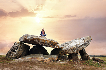 Young girl sitting on a Megalithic Dolmen, locality Le Carroir Bon Air, commune of Ligre, near Chinon and Richelieu,Indre-et-Loire department, Centre region,France, Europe