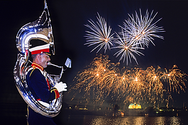 Sousaphone player with, in the background, fireworks above the Basilica during the 'Fetes du Bouffon' (Buffoon Festival) at Saint-Quentin, Aisne department, Picardy region, northern France, Europe