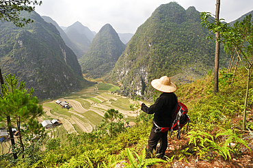 Man watching the landscape in Sa Phyn valley, Dong Van Karst Plateau Geopark, near Dong Van, Ha Giang province, Northern Vietnam, Southeast Asia