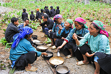 H'mong women and children taking communal lunch during funeral in a village around Sa Phin, Ha Giang province, Northern Vietnam, Southeast Asia
