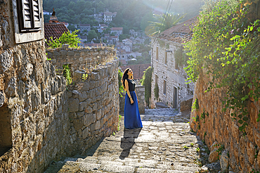 Woman walking on cobbled steps, Lastovo town, Lastovo island, Croatia, Southeast Europe