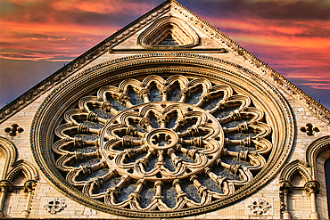 A large, circular stone window, known as a rose window, is featured in this image. The window is a centerpiece of a large, light-colored building and features a intricate design of arches and smaller windows in York, North Yorkshire, UK.