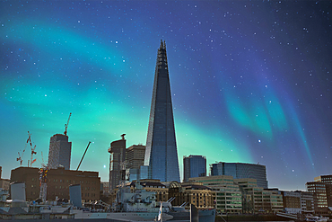 London's skyline, featuring the Shard, is depicted under a night sky with vibrant aurora borealis. Modern buildings and a historic ship are prominent.