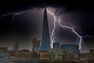 A nighttime cityscape featuring the Shard in London, England, is dramatically illuminated by several lightning strikes during a thunderstorm. Dark clouds fill the upper portion of the frame.