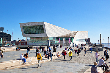 View of Museum of Liverpool with many people walking & sitting. Bright day with clear blue sky. Waterfront scene in Liverpool, UK.