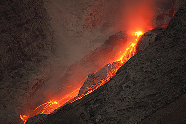 November 25, 2012 - Extrusion of lava through lava plug on top of conduit leads to small glowing rockfalls. Batu Tara volcano, Komba Island, Indonesia.
