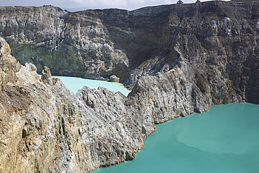 December 3, 2012 - Colourful crater lakes of Kelimutu volcano, Flores Island, Indonesia. A crater wall separates Tiwu Nua Muri Koo Fai (Lake of Young Men and Maidens) and Tiwu Ata Polo (Bewitched Lake). The two lakes are highly acidic due to underwater fumarole activity and are turqoise in colour.