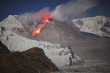 October 21, 2013 - Nighttime moonlit view of incandescent rockfall of glowing lava down flank of lava dome of Shiveluch Volcano, Kamchatka, Russia.