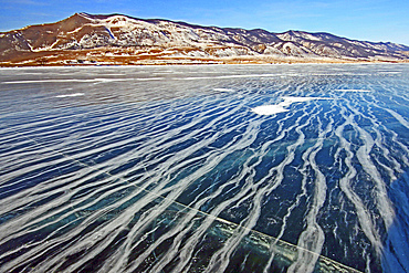 Stream of air bubbles caught in the ice when the lake froze, Lake Baikal, Russia.