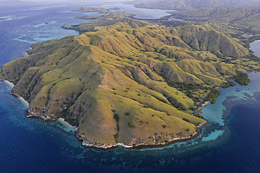 A bird's eye view shows the rugged landscape of Komodo Island in Komodo National Park, Indonesia. This tropical area in the Lesser Sunda Islands is known for its marine biodiversity as well as its infamous Komodo dragons.