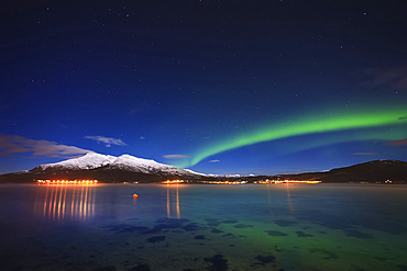 Aurora over Tjeldsundet and Saetertinden Mountain in Troms County, Norway. Auroras are the result of the emissions of photons in the Earth's upper atmosphere.