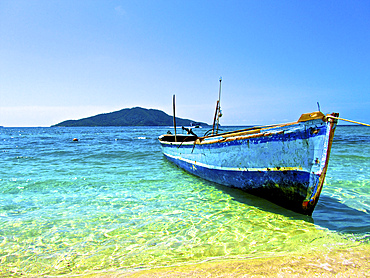 A lone boat on the shore of Cayos Cochinos, Honduras.