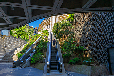 Passenger ascending on escalator from Les Halles to the Bourse on clear summer day