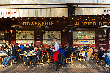 Waiter in red apron at Brasserie Au Pied du Cochon, Paris, France