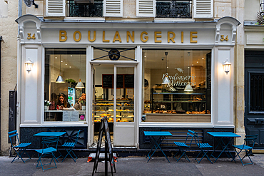 Two women drinking coffee in window of boulangerie in the Marais, Paris, France