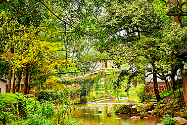 Stone bridge over a river in picturesque Guodong Ancient Village, Wuyi County, Jinhua City, Zhejiang Province, China. The 1000 year old village is still well inhabit with ancient buildings as early as the Wanli period (1573-1620) during the Ming Dynasty.