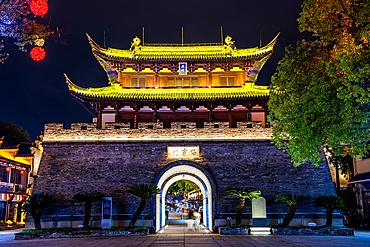 Baoning Gate (reconstructed 2004) at night. It houses the drum tower in Guzicheng, ancient city of Jinhua City, Zhejiang Province, China. The ancient city has a history of 1700 years and was the epicenter of Jinhua's historical development.