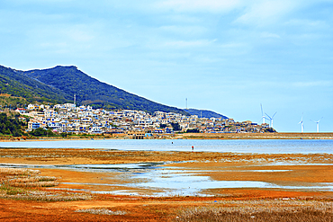Village by the sea with an accompaniment of windmills. Pingtan Island, Fuzhou City, Fujian Province, China.