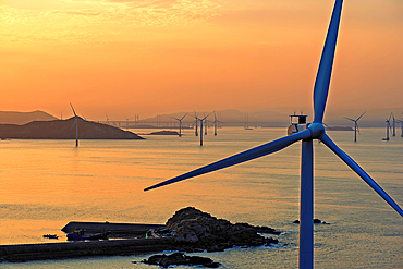 Windmills in a golden sunset. Pingtan Island, Fuzhou City, Fujian Province, China.