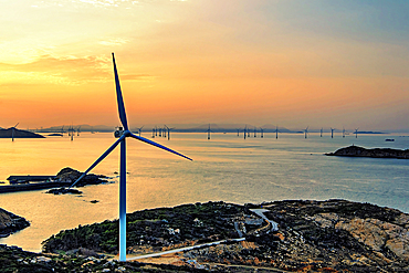Windmills in a golden sunset. Pingtan Island, Fuzhou City, Fujian Province, China.