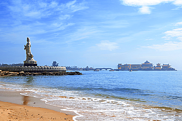 Majestic statue of Guanyin (Goddess of Mercy) with Luojia Temple in the sea in the background, Gold Coast, Shishi City, Fujian, China