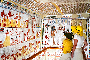 Tourists admiring ancient tomb paintings, Valley of the Nobles, West Bank, Luxor, Egypt