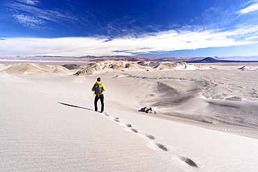 Tourist walking on white dunes, Campo de Piedra Pomez, El Penon, Puna, Catamarca, Argentina. (MR)