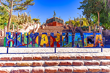 Sign on steps with the Monument to the Heroes of Independence on background, Humahuaca, Jujuy province, Argentina