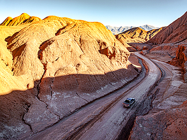 Car on a road alongside fossil cliffs, Labyrinth desert, Puna, Salta, Argentina