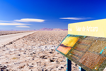 Informational sign board on side of an empty desert road in the wild dry landscape, Salar de Arizaro salt flat, Puna, Argentina