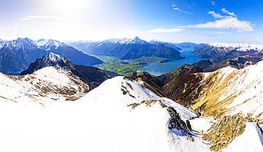 Aerial view of Colico, Monte Legnone and Lower Valtellina on a snowy spring, Lake Como, Lombardy, Italy