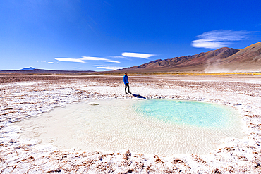 Man observing salt pond in salt desert, Ojos del Mar, Tolar Grande, Argentina