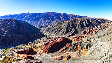 Aerial panoramic of the colorful striated mountains surrounding the old town of Purmamarca, Argentina