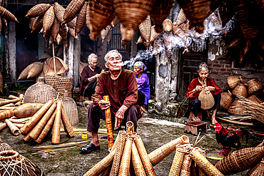 Man smoking while making bamboo fish traps, Hanoi, Vietnam. (MR)