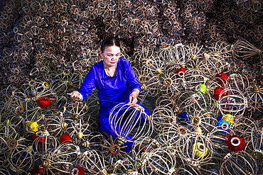 Woman assembling traditional lanterns, Hoi An, Quang Nam Province, Vietnam. (MR)