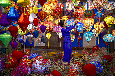 Woman arranging colorful lanterns in a workshop, Hoi An, Quang Nam Province, Vietnam. (MR)