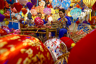 Woman making the traditional colorful lanterns, Hoi An, Quang Nam Province, Vietnam. (MR)