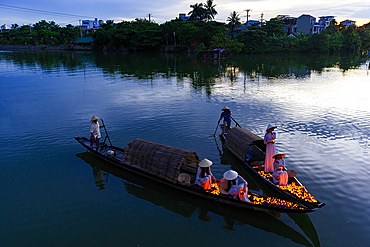 Women releasing floating lanterns with candles into Nhu Y River, Hue, Central Vietnam. (MR)