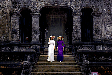 Women in ao dai and conical hat on steps at Khai Dinh Mausoleum, Hue, Central Vietnam. (MR)